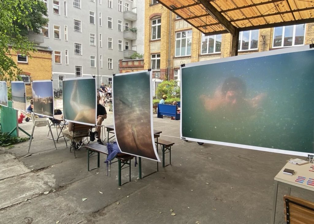 Reihe von Fotos, aufgehangen an Drahtseilen